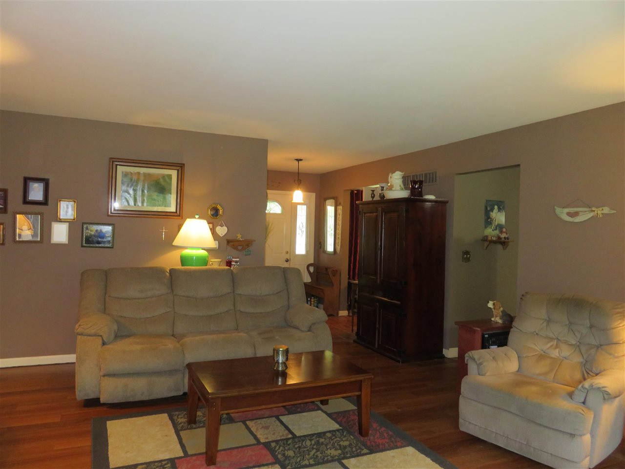 8766 Lovesee Road Roscoe, IL 61073 - Photo 16 of 27 a living room with furniture and a lamp
