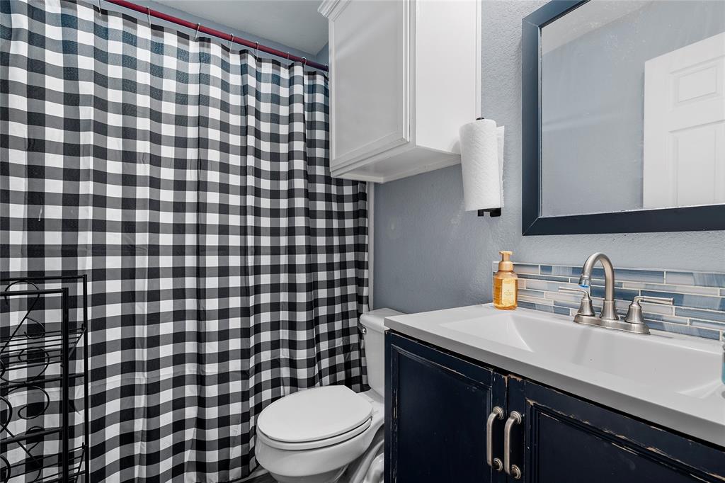 1108 Spring Street Waco, TX 76704 - Photo 13 of 17 a bathroom with a sink a toilet and a mirror