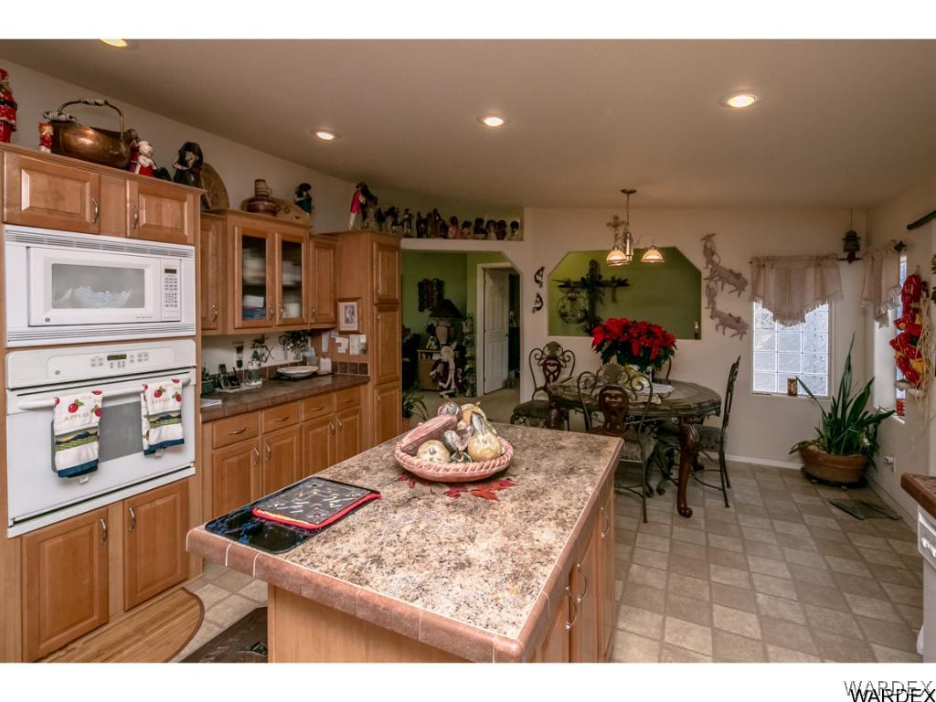 9701 East Blake Ranch Road Kingman, AZ 86401 - Photo 24 of 36 a kitchen with stainless steel appliances granite countertop a sink dishwasher and cabinets with wooden floor