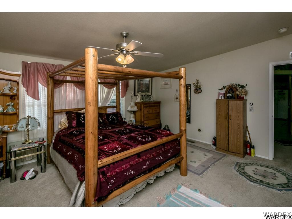 9701 East Blake Ranch Road Kingman, AZ 86401 - Photo 5 of 36 a bedroom with a bed and a chandelier