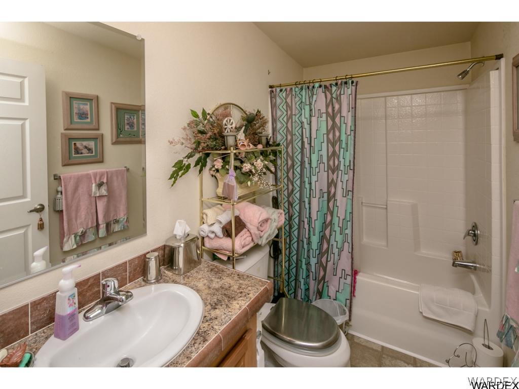 9701 East Blake Ranch Road Kingman, AZ 86401 - Photo 8 of 36 a bathroom with a granite countertop sink a mirror and shower