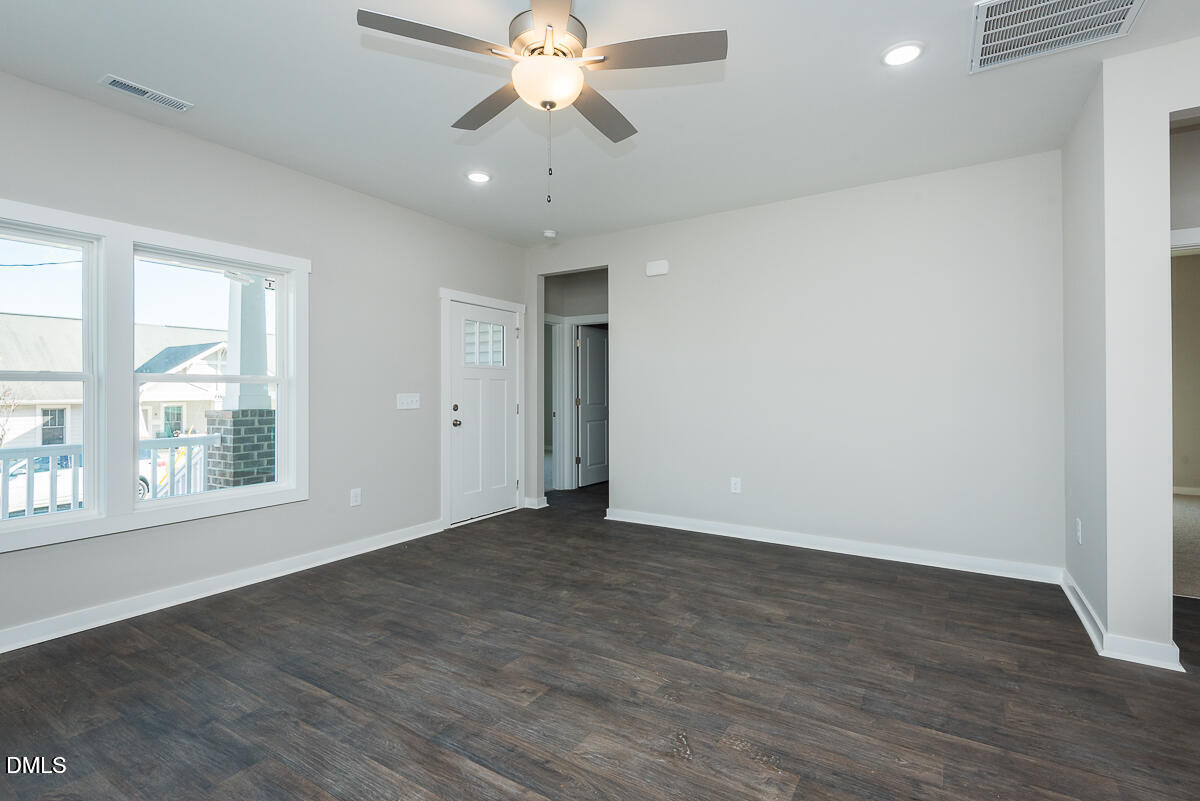 555 Pinnix Road Burlington, NC 27217 - Photo 4 of 20 an empty room with wooden floor fan and windows