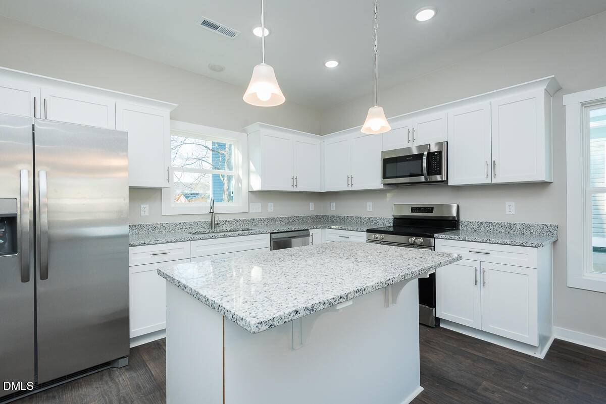 555 Pinnix Road Burlington, NC 27217 - Photo 7 of 20 a kitchen with kitchen island granite countertop a sink stainless steel appliances and white cabinets