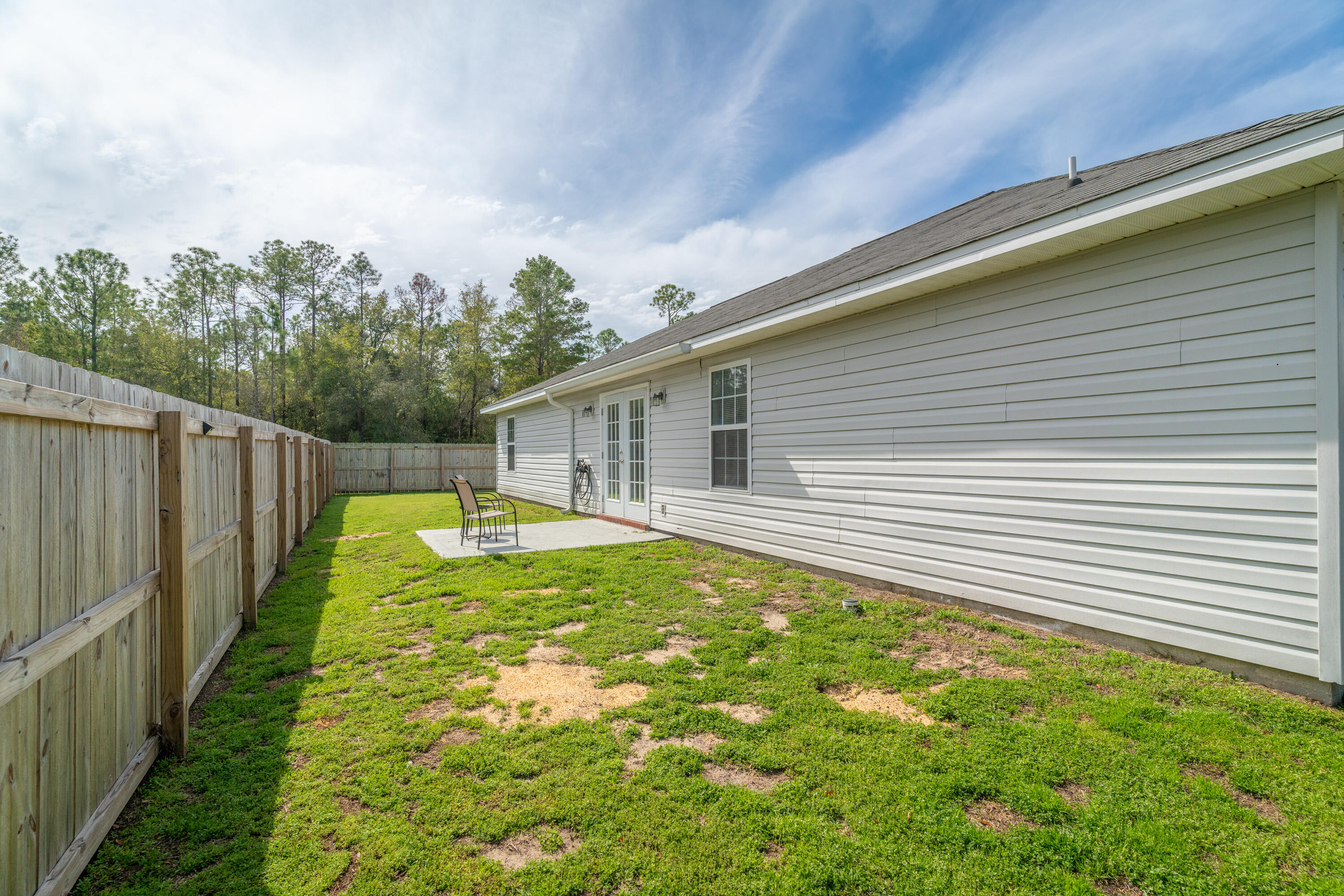 5191 Quince Avenue Crestview, FL 32539 - Photo 38 of 45 a view of a backyard with table and chairs and wooden fence