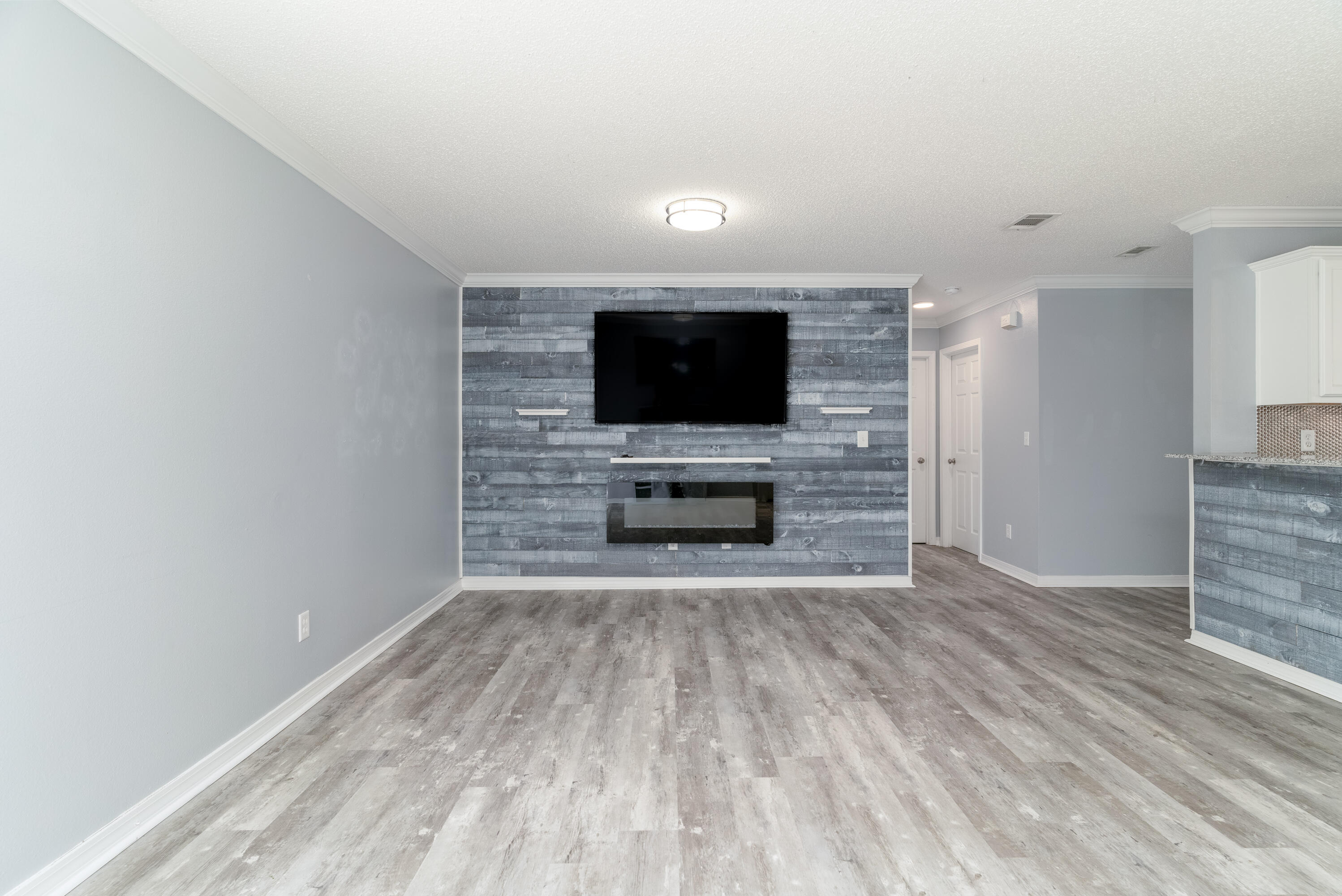5191 Quince Avenue Crestview, FL 32539 - Photo 10 of 45 a view of a livingroom with a flat screen tv wooden floor and staircase
