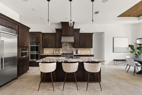 a kitchen with stainless steel appliances granite countertop a sink and a refrigerator