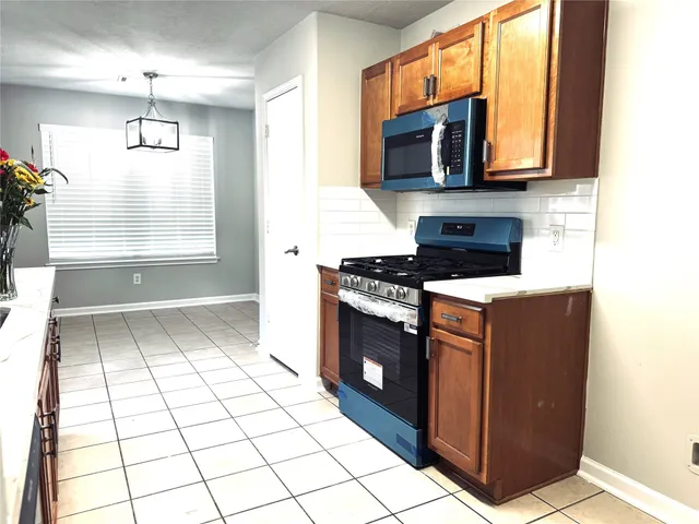 a kitchen with granite countertop a stove a microwave and a sink