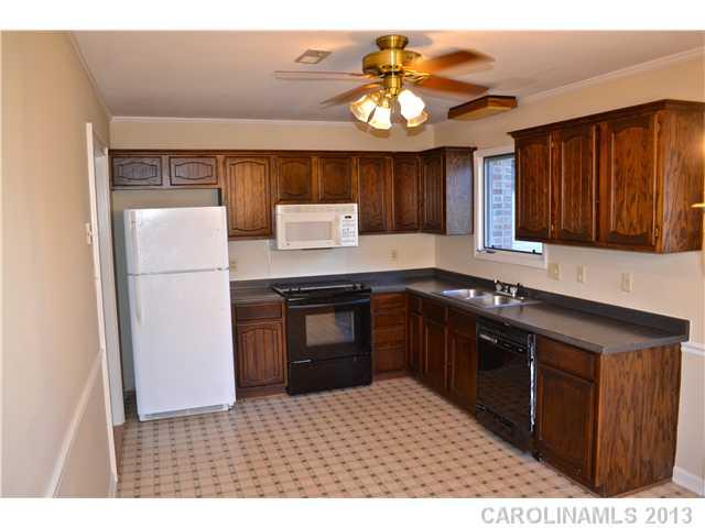 3417 Sandy Porter Road Charlotte, NC 28273 - Photo 8 of 12 a kitchen with stainless steel appliances granite countertop a refrigerator a sink dishwasher a stove with wooden cabinets