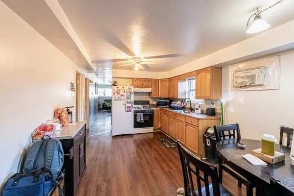 a kitchen with a sink appliances cabinets and wooden floor