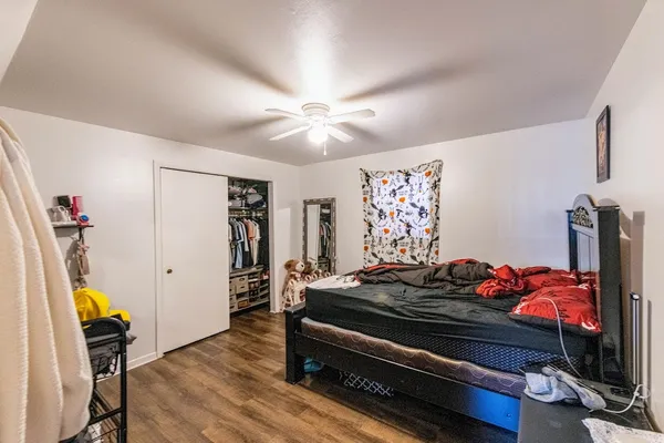 a bedroom with a bed and wooden floor