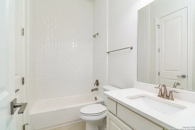 a bathroom with a bathtub shower sink vanity mirror and toilet