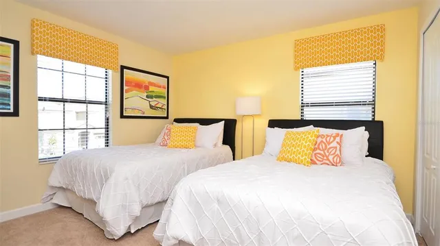 a bedroom with two beds and a large window