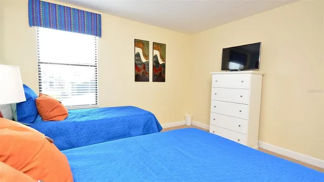 a bedroom with two beds and a flat screen tv