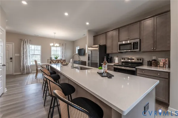 a kitchen with stainless steel appliances a stove a sink a microwave a refrigerator and cabinets