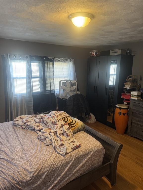 21 Cook, Unit 1 Chelsea, MA 02150 - Photo 13 of 32 a bedroom with a bed and wooden floor