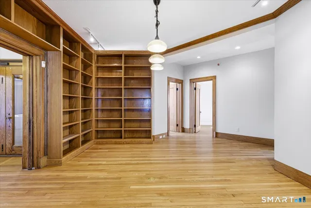 a view of an empty room with a window and wooden floor
