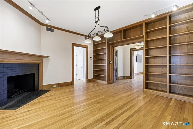 a view of a livingroom with wooden floor staircase and a ceiling fan