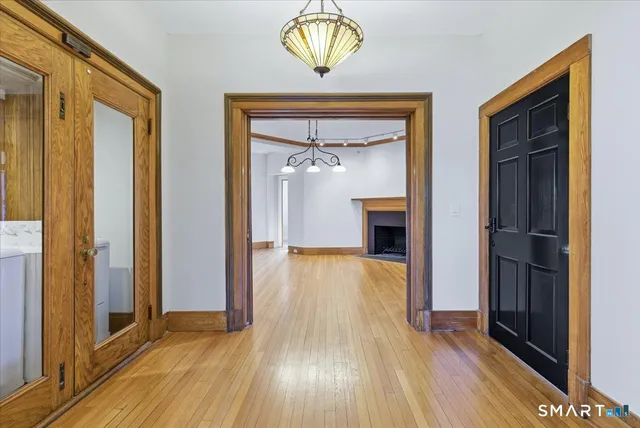 a view of empty room with wooden floor and fan