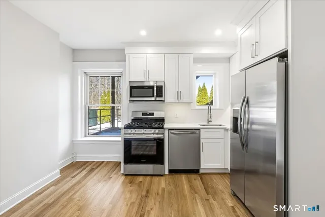 a kitchen with stainless steel appliances a refrigerator sink and stove