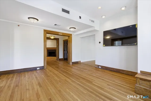 a view of an empty room with wooden floor