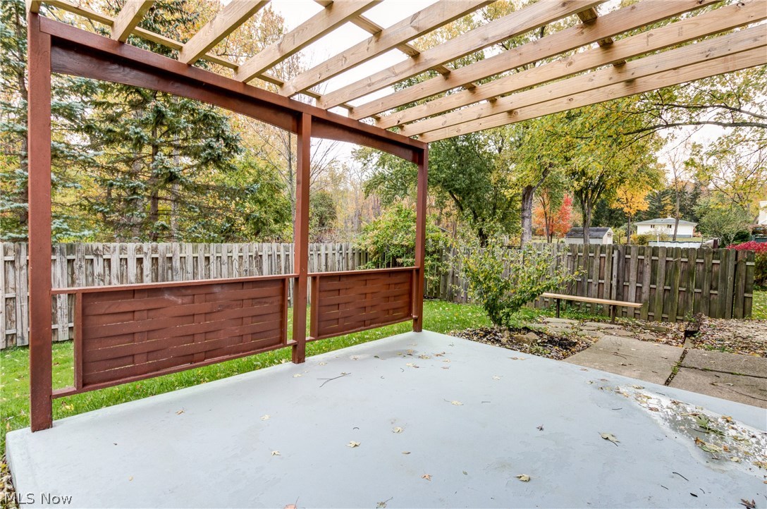 38705 Chardon Road Willoughby Hills, OH 44094 - Photo 32 of 35 Patio out back with wood roof that minimizes the suns direct effects on the patio...with bench and privacy fence....nice landscaping....pavers for walk way....a lot of room for this yard for your family to roam