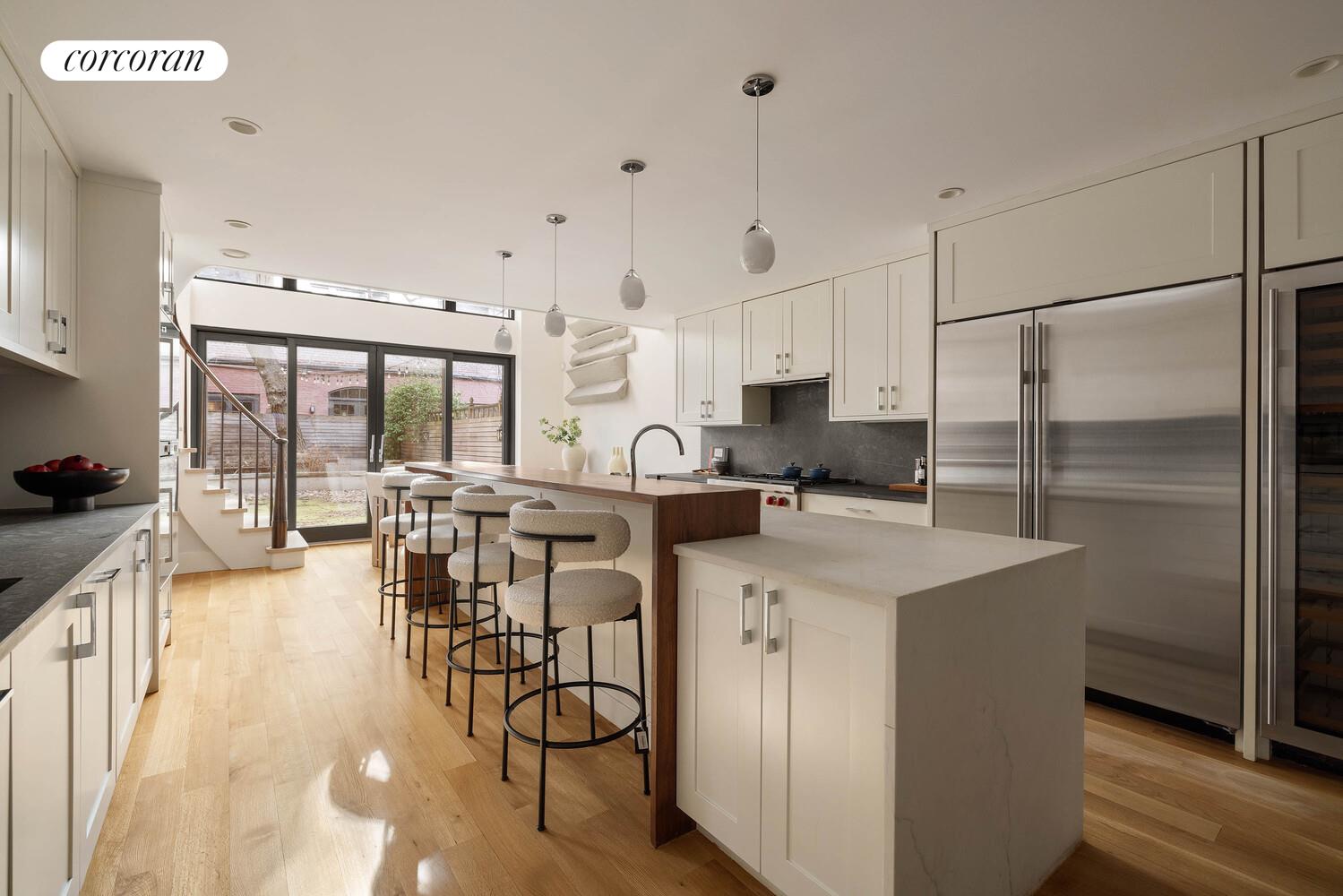 53 West 71st Street Manhattan, NY 10023 - Photo 13 of 41 a kitchen with stainless steel appliances a table chairs refrigerator and cabinets