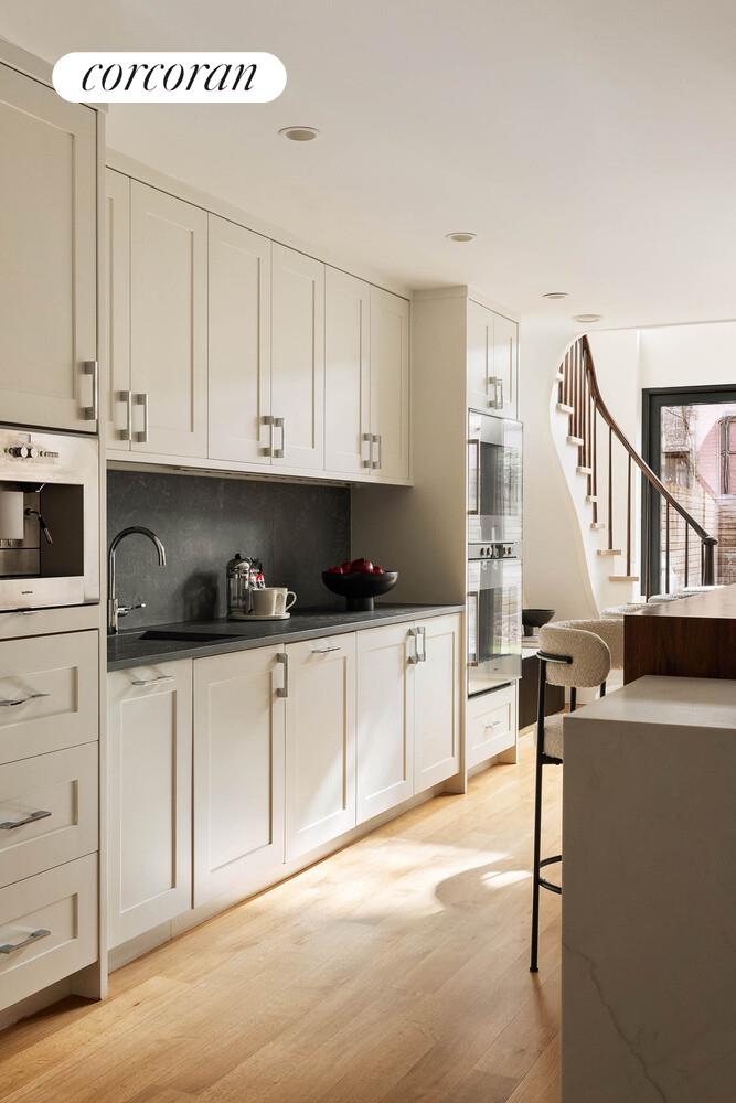 53 West 71st Street Manhattan, NY 10023 - Photo 14 of 41 a kitchen with stainless steel appliances granite countertop a sink a stove and white cabinets