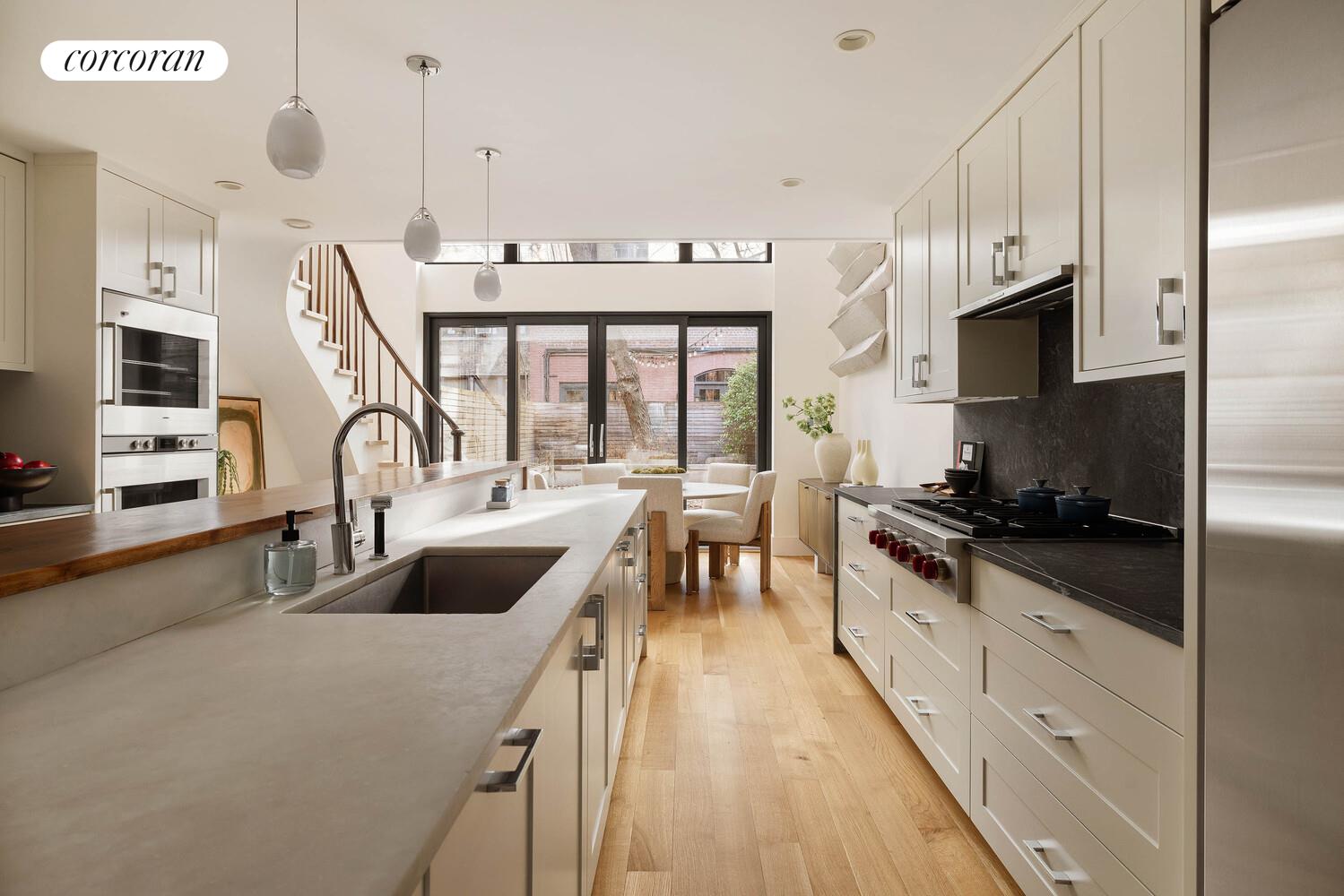 53 West 71st Street Manhattan, NY 10023 - Photo 15 of 41 a kitchen with stainless steel appliances a sink a stove top oven a chimney and a center island
