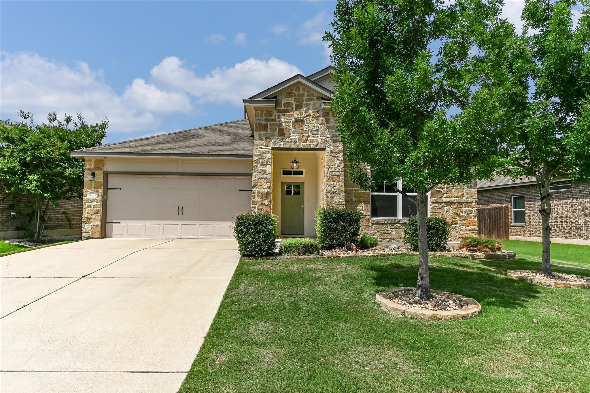 4333 Buffalo Ford Road Georgetown, TX 78628 - Photo 1 of 1 View of front facade with stone siding, driveway, an attached garage, and a front lawn