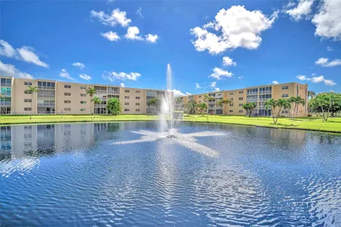 a view of a swimming pool with a lake view and a large trees
