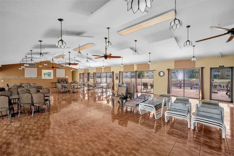 a large room with lots of tables a large window and chairs