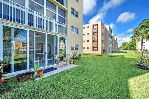 a view of a building with a yard and sitting area