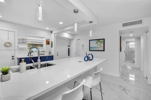 a kitchen with stainless steel appliances kitchen island granite countertop a sink and a refrigerator