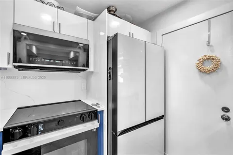 a kitchen with a refrigerator and a stove top oven