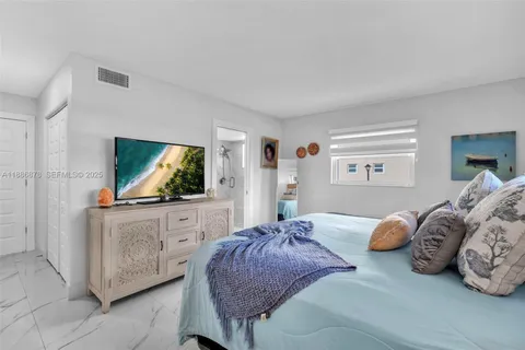 a bedroom with a bed and flat screen tv
