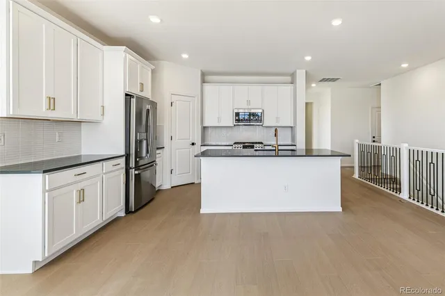 a kitchen with stainless steel appliances a refrigerator sink and cabinets