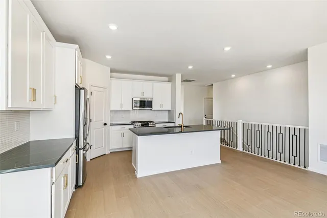 a kitchen with stainless steel appliances a sink stove and refrigerator