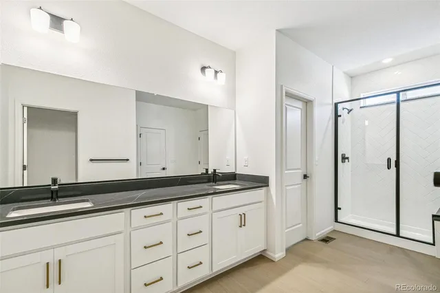 a spacious bathroom with double sink and a mirror