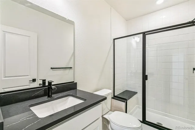 a bathroom with a sink vanity mirror and toilet