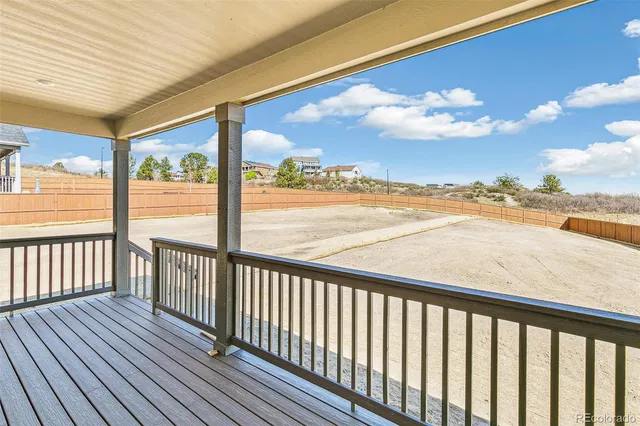a view of a balcony with wooden floor & fence