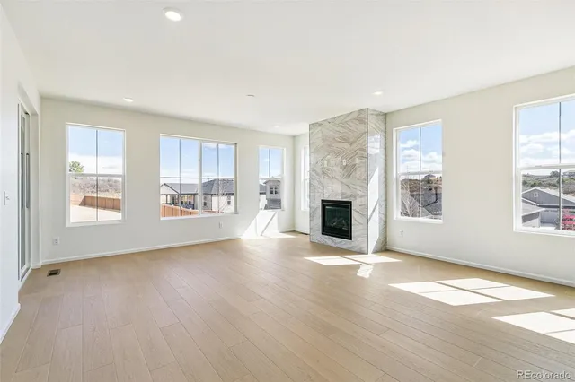 a view of an empty room with window and fire place