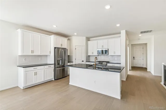 a kitchen with stainless steel appliances granite countertop a stove and a refrigerator