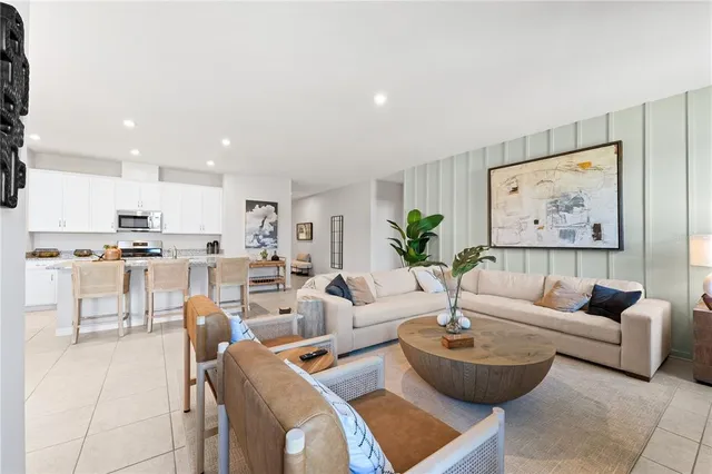 a living room with furniture and a view of kitchen