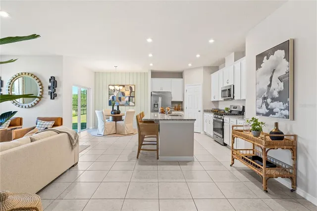 a living room with furniture a dining table and kitchen view