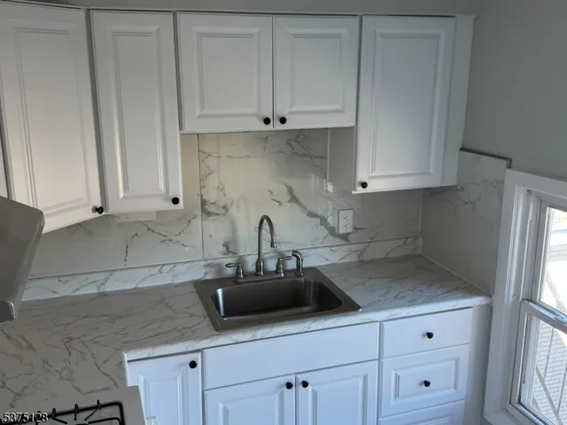 a kitchen with white cabinets and a sink