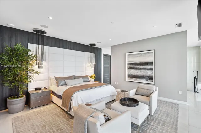 a bedroom with a large bed and a chandelier