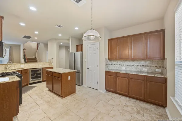 a large kitchen with stainless steel appliances granite countertop a lot of cabinets and couches