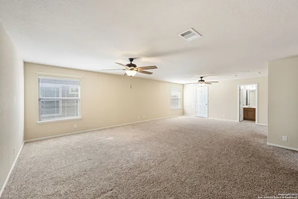 a view of a big room with chandelier fan and windows