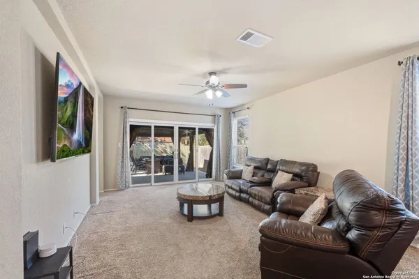 a living room with furniture and a ceiling fan