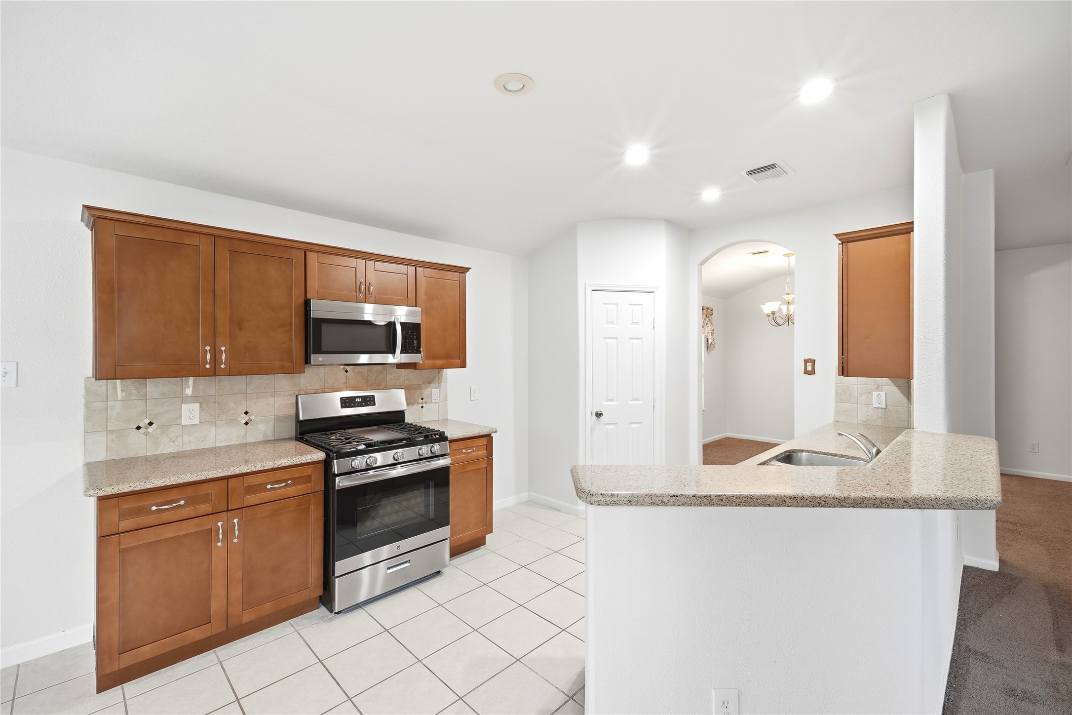 5411 Gate Canyon Court Spring, TX 77373 - Photo 12 of 33 a kitchen with stainless steel appliances granite countertop a stove a sink and a refrigerator